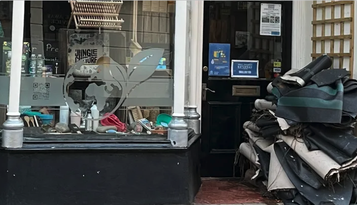 A pile of floor coverings can be seen outside Our Precious Earth after September's flooding in Minehead.