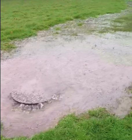 Raw sewage forcing itself through a sewer pipe manhole cover and running toward the River Avill, in Timberscombe. 