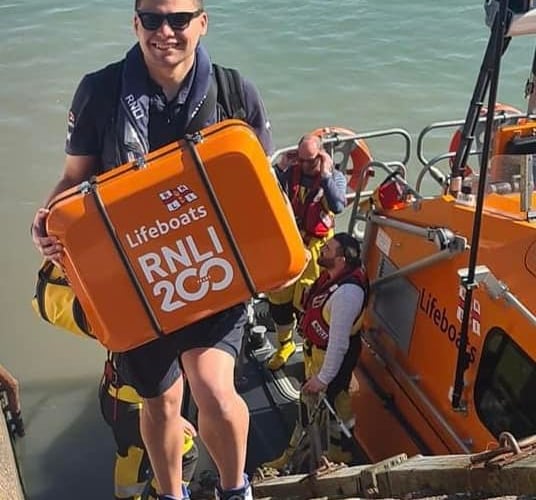 Ilfracombe RNLI crew members deliver the charity's 200th anniversary scroll to Minehead.