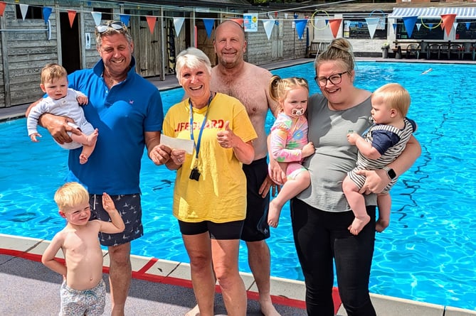 Wivey Pool chairman Liz Hurry (centre) receives a £1,000 cheque from (left to right) Riley and Kit Kennett, Martin Greenway, Chris Briggs, Darcie, Oscar, and Charmaine Veryard.