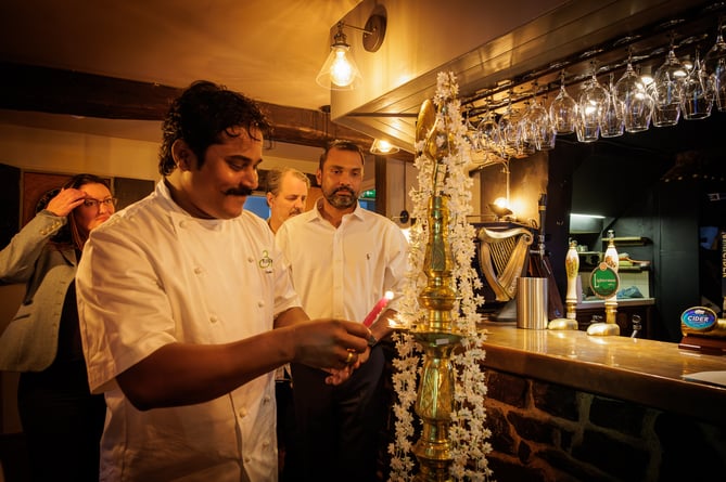 Chef Chanaka Fernando lights a candle wick set in coconut oil for a Puja ceremony at the reopening of The Rock Inn, Waterrow, near Wiveliscombe. PHOTO: Carlos Farinha.