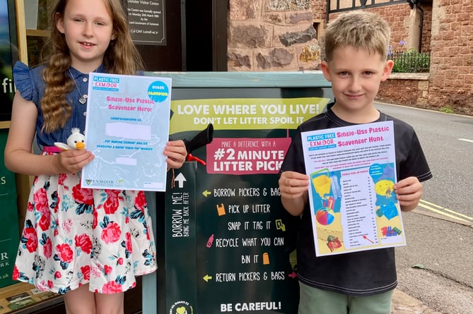 Two visiting children collect their single-use plastic scavenger hunt forms from the National Park Centre, in Dunster.