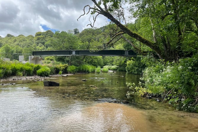 The main beam is put in place for Exmoor's Great Bradley Bridge, on the River Barle.