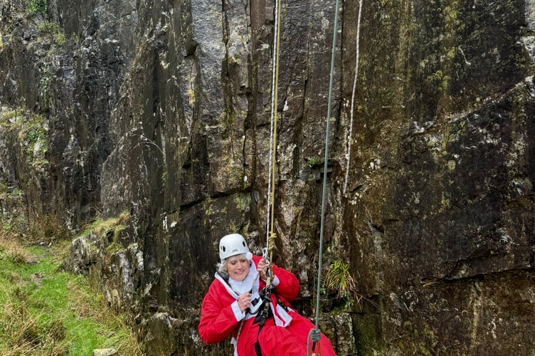 Watchet's Sam Westmacott completes her Santa abseil in Cheddar Gorge for St Margaret's Hospice.